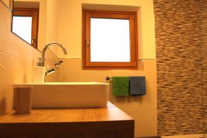 a bathroom with a sink and a window at Lü de Terza in San Vigilio Di Marebbe +18 photos