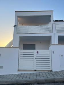 a white house with a white garage door at Appart NUOVO Sorgenti Sup by Salento Prime in Marina di Pescoluse