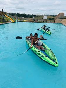 two people in a kayak in the blue water at The Essence Resort in Clarence +13 photos