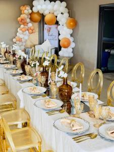 a long table with white table cloth and gold chairs at The Essence Resort in Clarence
