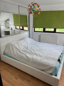 a bedroom with a bed with a mirror and a chandelier at House in the new center,Brasov in Braşov
