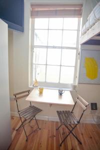 a table and two chairs in a room with a window at Two Top Central Unique Artisan Beach Studios - also separate spa cabin in Brighton & Hove