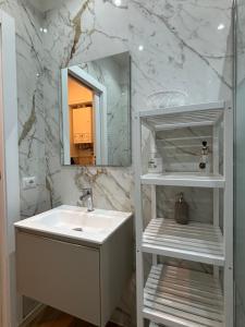 a white bathroom with a sink and a mirror at Bella Como Holiday Apartment in Como