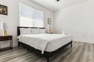 ein weißes Schlafzimmer mit einem großen Bett und einem Fenster in der Unterkunft Glendale CozySuites - Westgate with pool 10 in Glendale