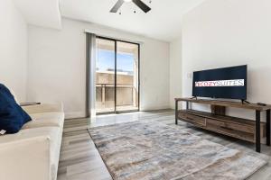 ein Wohnzimmer mit Fernseher und Sofa in der Unterkunft Glendale CozySuites - Westgate with pool 10 in Glendale