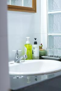 a bathroom sink with a bottle of soap and a mirror at Elite Home stays by UPAR, Silom in Bangkok +11 photos