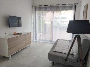 a living room with a tv and a dresser and a window at Cocon avec piscine et clim sur la Côte d'Azur in Vidauban