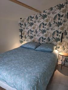 a bedroom with a blue bed with a floral wallpaper at Cocon avec piscine et clim sur la Côte d'Azur in Vidauban +22 photos