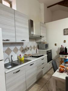 a kitchen with white cabinets and a sink at Da Raffaella affittacamere in Cicciano