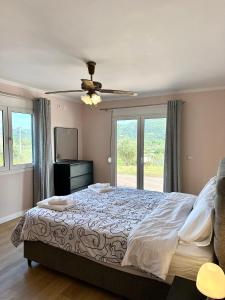 a bedroom with a bed and a ceiling fan at Perl's Apartment in Póndi