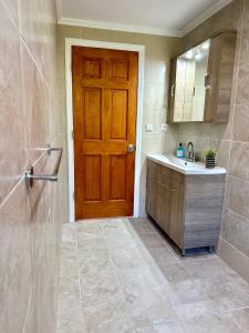 a bathroom with a wooden door and a sink at Perl's Apartment in Póndi +28 photos