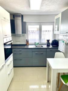 a kitchen with blue cabinets and a sink and a table at Ferienwohnung Seehas am Bodensee in Friedrichshafen +6 photos