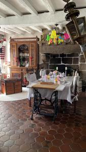 een eetkamer met een tafel en een open haard bij Suite Retour en Enfance in Dol-de-Bretagne +22 foto's