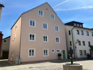 a large white building next to a white building at Ferienwohnung Altstadtliebe mit Dachterrasse in Riedenburg