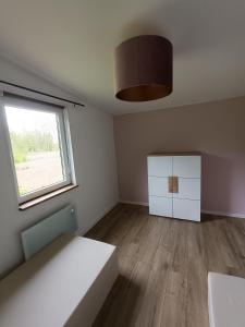 een lege kamer met een bed en een raam bij Dom wśród łąk in Suwałki +14 foto's