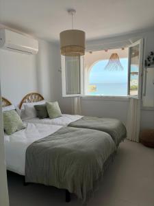 a bedroom with a large bed and a window at El Mirador de NaLi - accès direct à la plage in Arenal d'en Castell