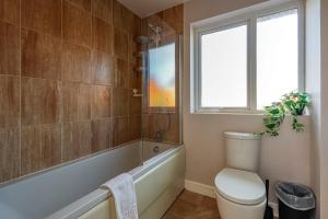 baño con aseo, bañera y ventana en Noah Suite - Central 2BR Apartment with Parking & WIFI, en Cardiff 14 fotos más