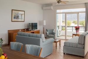 a living room with a couch and a tv at Ostria View in Kardamaina