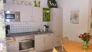 Una cocina con gabinetes blancos y una mesa. en Landleben, en Fritzlar