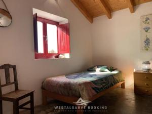 une chambre avec un lit, une chaise et une fenêtre dans l'établissement Countryhome Pomar, à Odeceixe