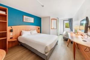 a hotel room with a bed and a desk and a bed at Comfort Hotel Evreux in Évreux