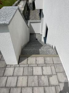 a stairway leading up to a white building at Ferienwohnung In Ruhiger Lage In Seenähe in Oberteuringen