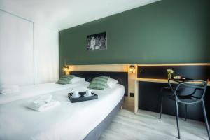 a hotel room with two beds with green walls at City Résidence Tours in Tours
