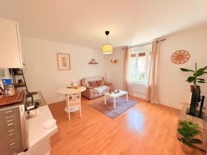 a living room with a couch and a table at l'Escapade aux portes de Strasbourg - Cosy & lumineux in Schiltigheim