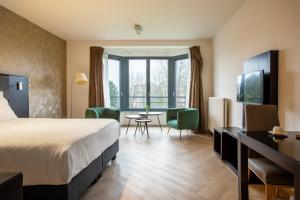 a hotel room with a bed and a table and chairs at Diamant Suites Brussels EU in Brussels