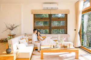 a couple sitting on a couch in a living room at U AND ME 6395 DOICHANG in Ban Huai Khai +47 photos