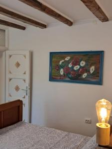 a bedroom with a painting of flowers on the wall at 1918Apartman Šibenik centar,Poljana in Šibenik