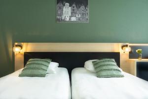 two beds sitting next to each other in a room at City Résidence Tours in Tours +21 photos