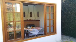 a glass window with a table and a fireplace at Pousada Santo Antônio do Pinhal in Santo Antônio do Pinhal