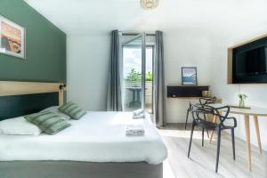 图尔City Résidence Tours的一间卧室，配有一张床、一把椅子和一台电视机