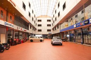 a building with cars parked in the middle of a street at Kalanad Residency And Convention Centre in Kalanādu
