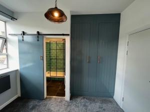 a hallway with a blue door and a window at Warehouse Conversion Flat in London