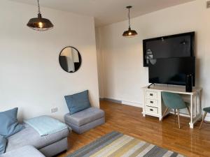 a living room with a couch and a flat screen tv at Warehouse Conversion Flat in London
