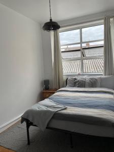 a bedroom with a bed in front of a window at Warehouse Conversion Flat in London