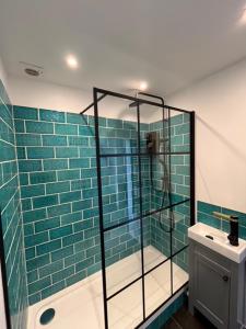 a bathroom with a glass shower and a sink at Warehouse Conversion Flat in London