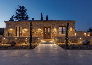a stone house with a front entrance at night at Le tresor de Marie - Charming Traditional Retreat, by ZanteWize in Gaïtánion +42 photos