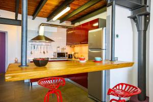 ギッファにあるLa Filanda: Loftの木製のカウンターと2脚の赤い椅子があるキッチン