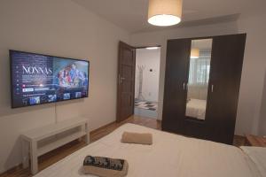 a bedroom with a bed and a tv on the wall at Focalize Apartament in Buzau