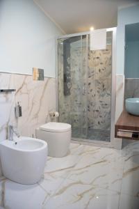 a bathroom with a shower and a toilet and a sink at La Dolce Vita rooms & suite in Agrigento