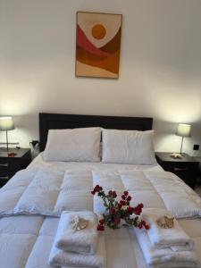 a large white bed with towels and flowers on it at STYILEL apartment MIlos 2 in Triovasálos