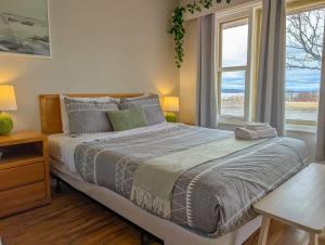 a bedroom with a large bed with a window at Studio 15 - 2 min du Bord de l'eau & Foyer &Barbecue in Sainte-Anne-de-Beaupré