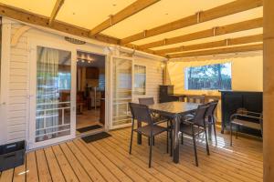 une salle à manger avec une table et des chaises sur une terrasse dans l'établissement Mh 25 Les Genêts Ronce les bains, à La Tremblade 11 autres photos