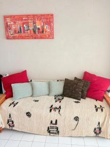 a bedroom with a large bed with colorful pillows at Les Sables Fins, Joli Appartement Front de Mer, 1 min des plages, Parking in Sète