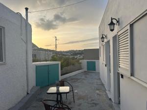 an alley with two chairs and a table on a balcony at STYILEL apartment MIlos 2 in Triovasálos