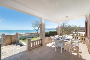 eine Terrasse mit Tisch und Stühlen und dem Meer in der Unterkunft Borges in Son Serra de Marina