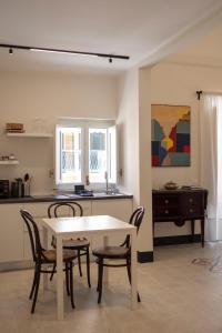 a dining room with a table and chairs and a kitchen at Studio Matteotti in Cefalù